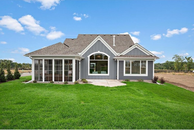 back of house with a yard, a sunroom, and a patio area