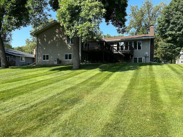 back of property featuring a lawn and a deck