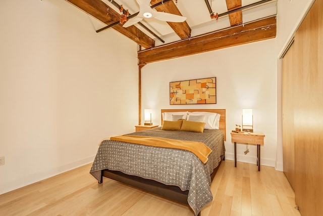 bedroom featuring ceiling fan, a closet, beam ceiling, and light hardwood / wood-style floors