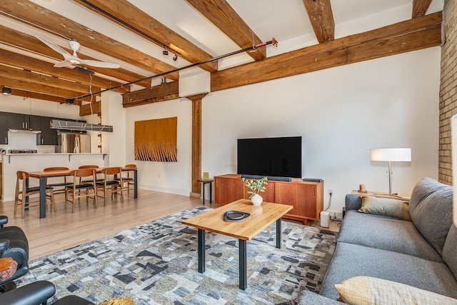 living room featuring hardwood / wood-style flooring, beam ceiling, and ceiling fan