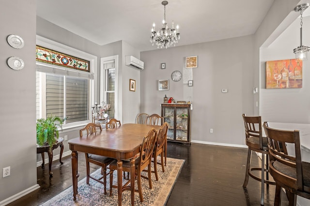 dining area featuring dark hardwood / wood-style floors, a wall unit AC, and a notable chandelier