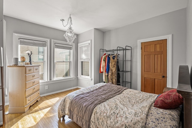 bedroom featuring light hardwood / wood-style flooring and a chandelier