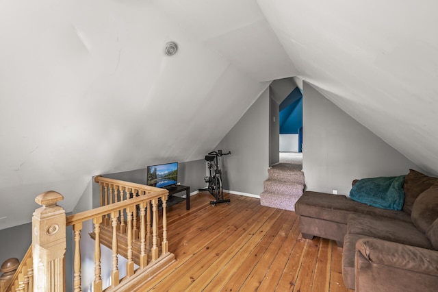 additional living space with vaulted ceiling and hardwood / wood-style floors