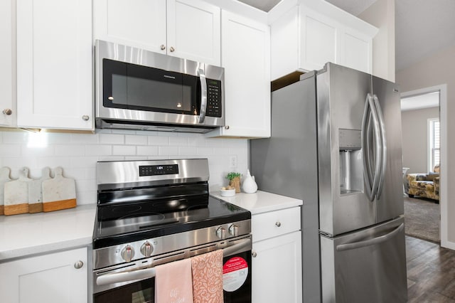 kitchen with decorative backsplash, dark hardwood / wood-style floors, white cabinets, and appliances with stainless steel finishes