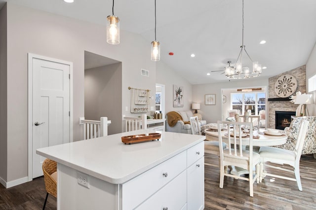 kitchen with white cabinetry, decorative light fixtures, dark hardwood / wood-style flooring, and a center island