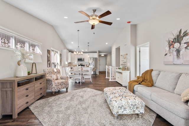 living room featuring dark wood-type flooring, ceiling fan with notable chandelier, and high vaulted ceiling