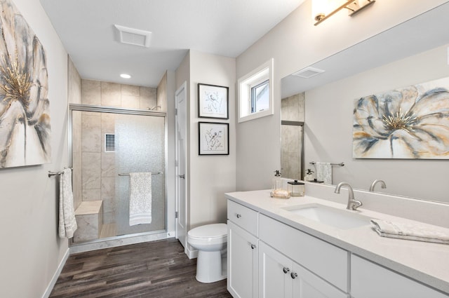 bathroom with vanity, toilet, a shower with door, and hardwood / wood-style floors