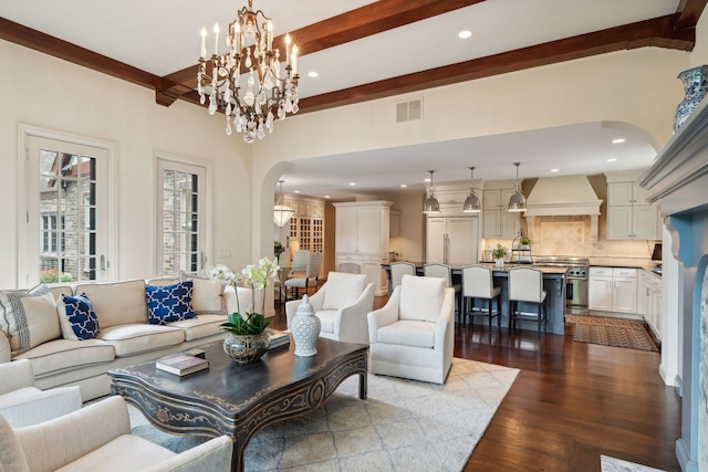 living room featuring wood-type flooring, beam ceiling, and a notable chandelier