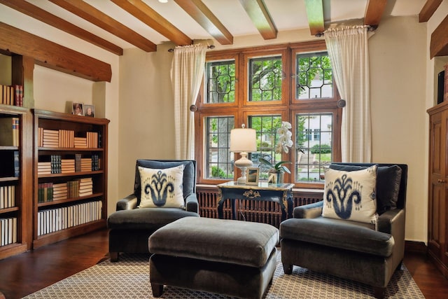 living area with beamed ceiling, plenty of natural light, and dark wood-type flooring