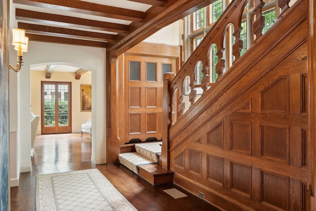 foyer entrance with beamed ceiling and dark wood-type flooring