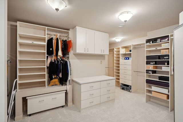 walk in closet featuring light colored carpet