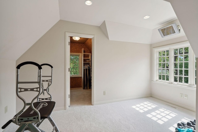 workout room featuring lofted ceiling and light colored carpet