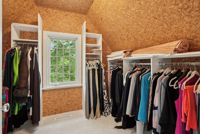 spacious closet featuring lofted ceiling and carpet floors