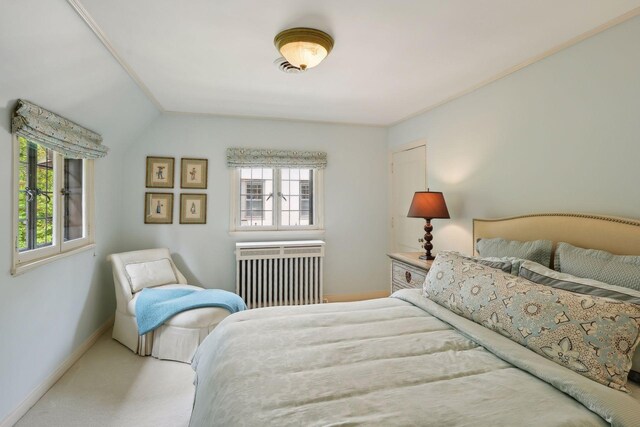 carpeted bedroom with ornamental molding, radiator, and vaulted ceiling