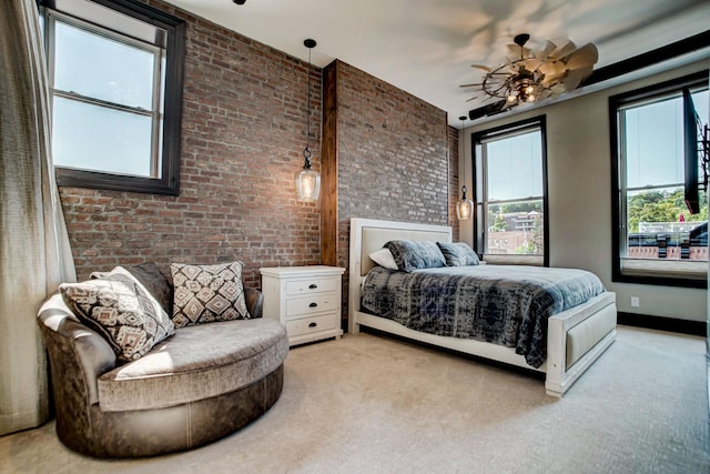 bedroom with ceiling fan, light carpet, and brick wall