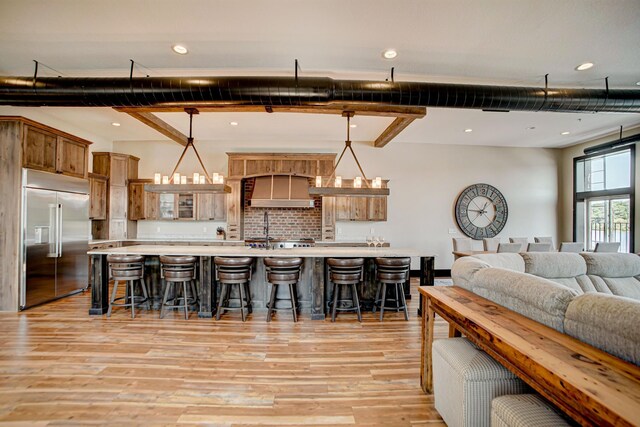 kitchen featuring a chandelier, a kitchen bar, hanging light fixtures, and built in refrigerator