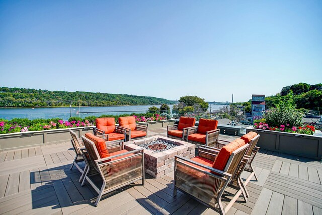 wooden deck featuring a water view and an outdoor fire pit