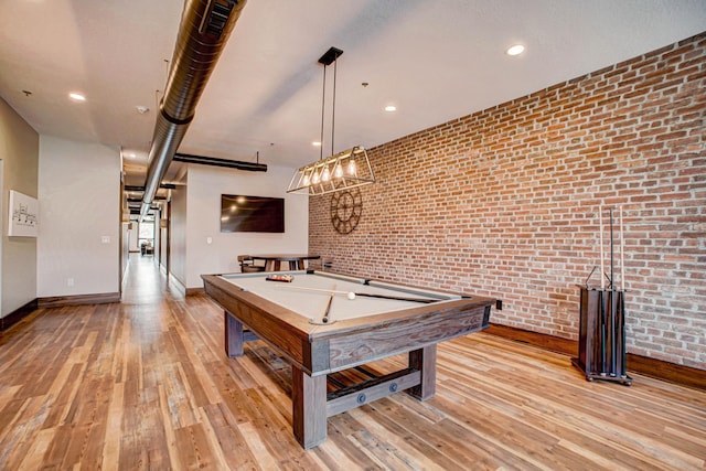 rec room featuring pool table, light wood-type flooring, and brick wall