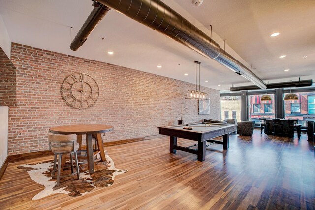 playroom featuring hardwood / wood-style flooring, billiards, and brick wall