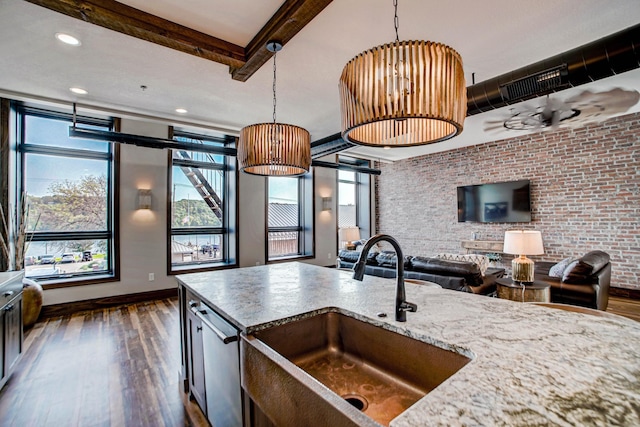 kitchen with pendant lighting, dark hardwood / wood-style flooring, beam ceiling, and sink