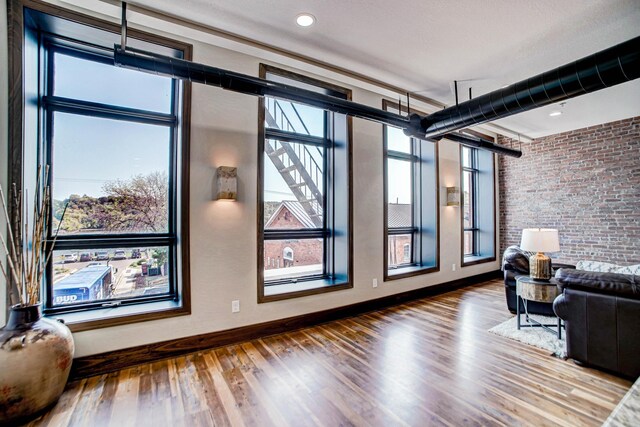 living room featuring brick wall and hardwood / wood-style flooring