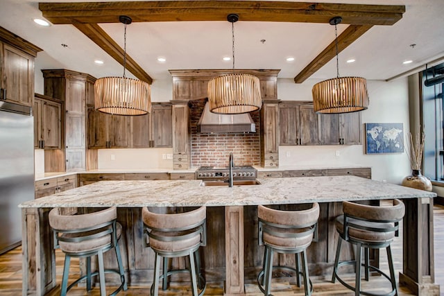 kitchen featuring a large island with sink and pendant lighting