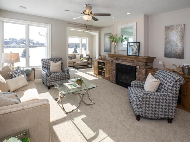 carpeted living room with ceiling fan and a brick fireplace