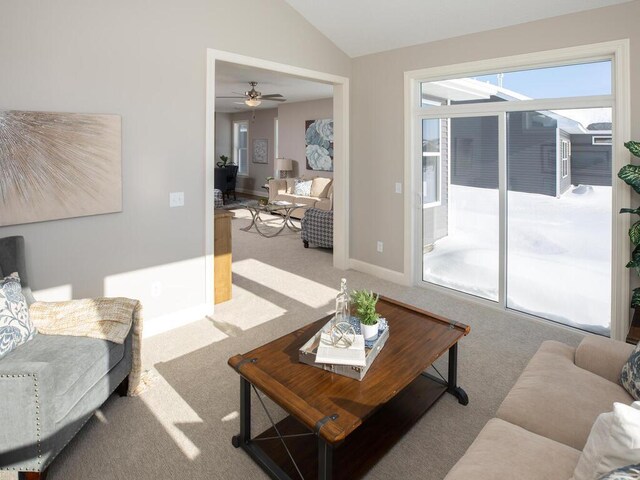 living room featuring carpet, ceiling fan, and vaulted ceiling