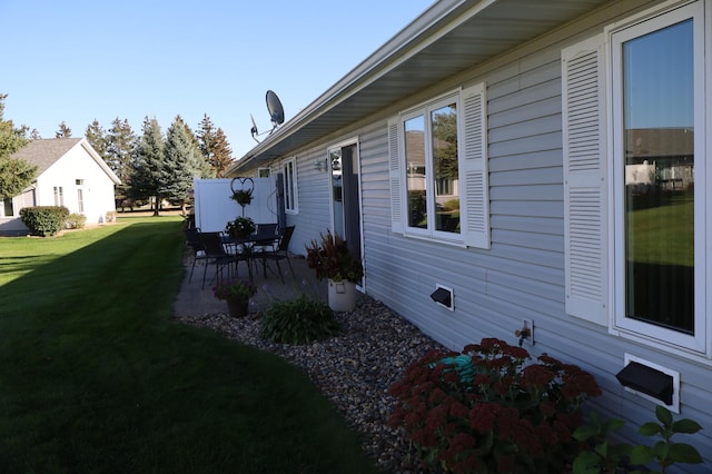 view of side of property with a patio area and a yard