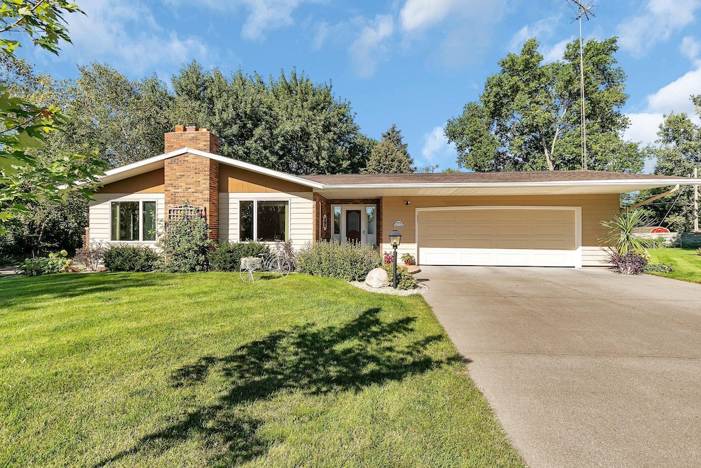 ranch-style house with a front yard and a garage