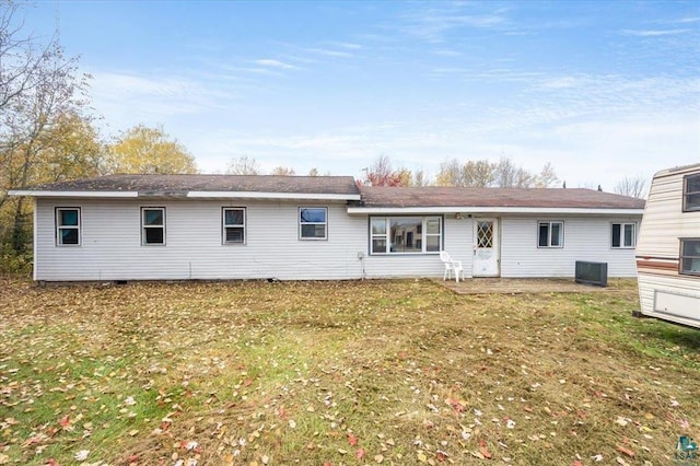 back of property featuring central AC unit and a yard