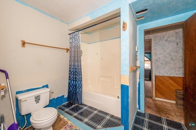 bathroom featuring shower / tub combo, wooden walls, and toilet