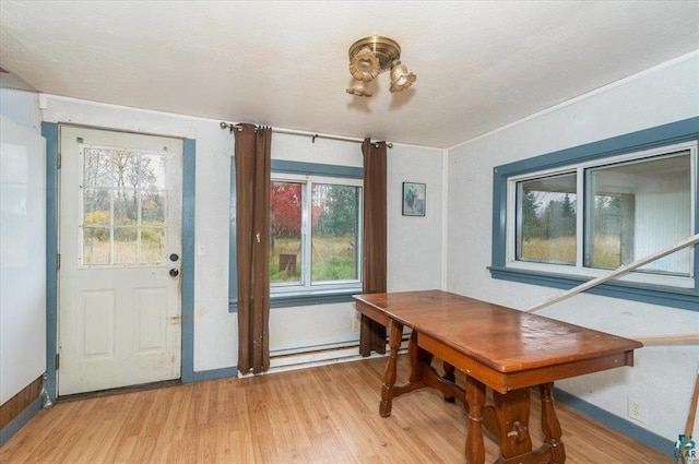 dining room featuring a baseboard heating unit and light wood-type flooring