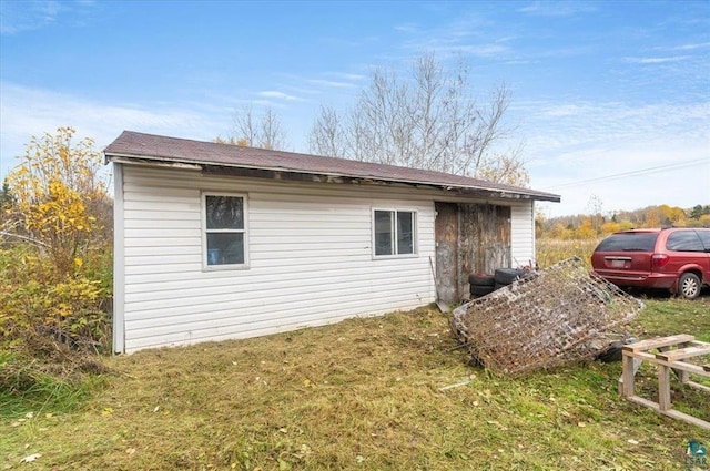 view of property exterior with an outbuilding and a yard