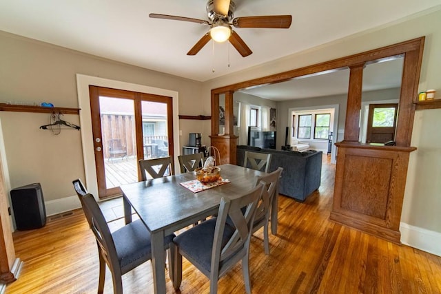 dining room with decorative columns, ceiling fan, and hardwood / wood-style floors