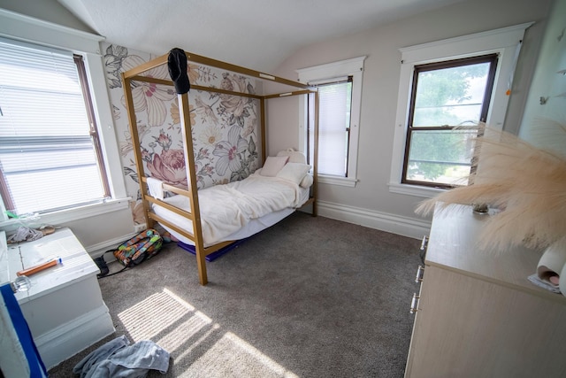 unfurnished bedroom with dark colored carpet and lofted ceiling