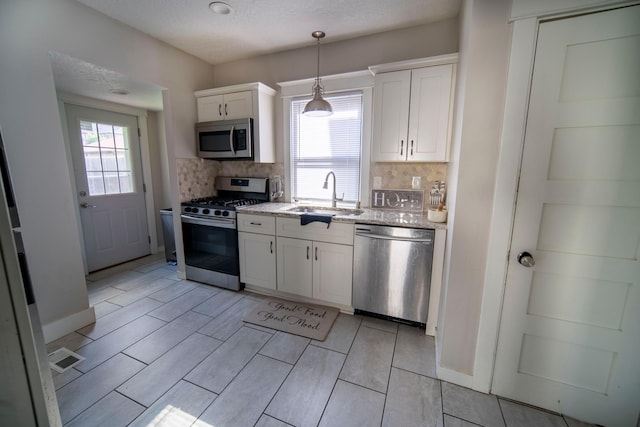 kitchen featuring sink, white cabinets, plenty of natural light, and appliances with stainless steel finishes