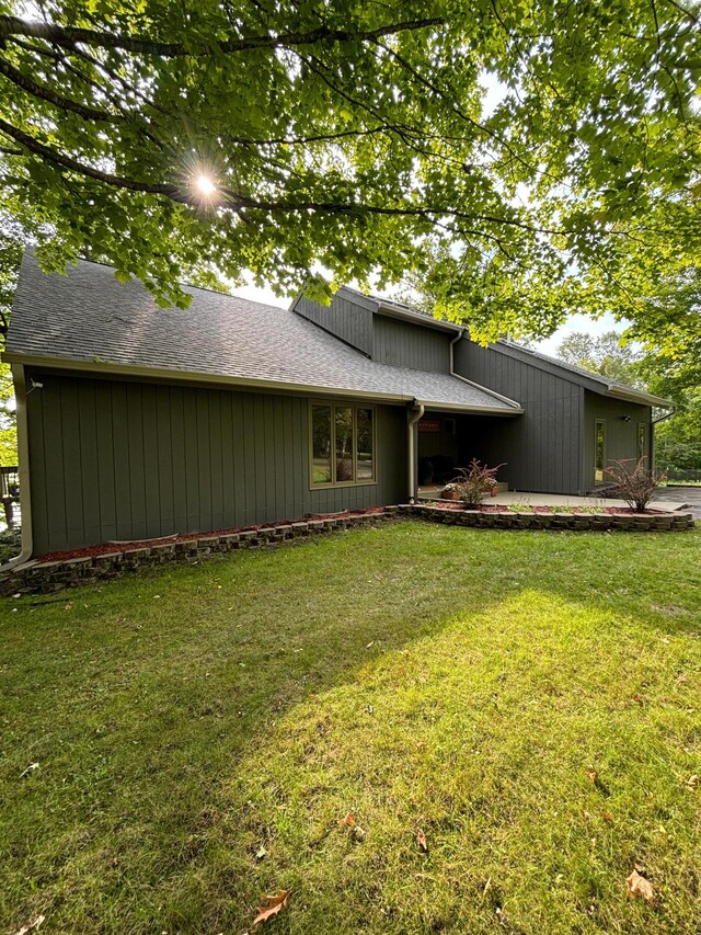 rear view of property featuring a lawn