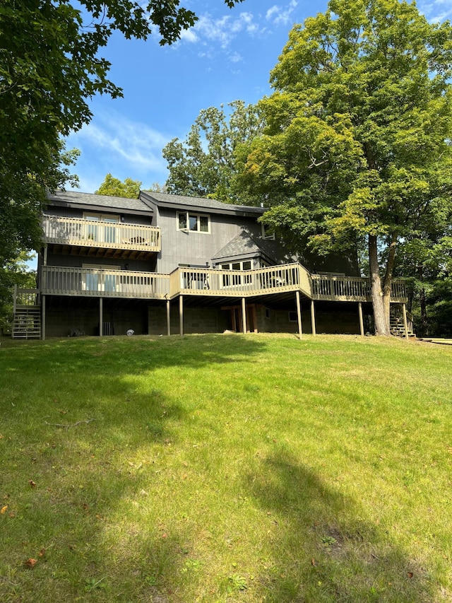 rear view of property featuring a yard and a wooden deck