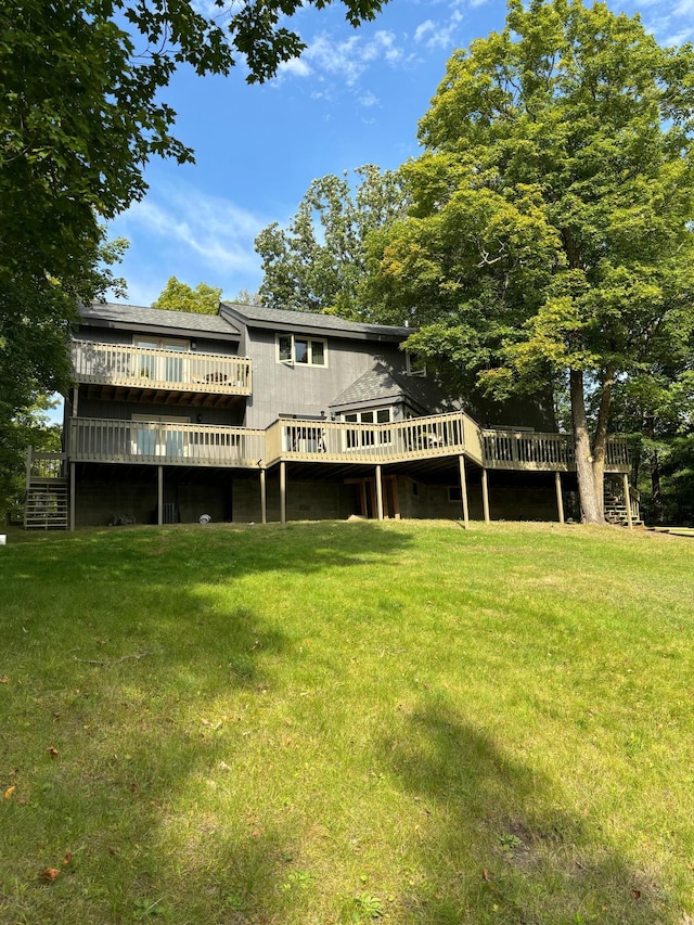 rear view of house featuring a yard and a wooden deck