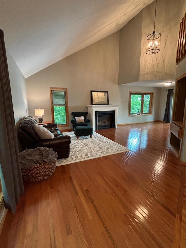 living room featuring hardwood / wood-style floors, high vaulted ceiling, and a chandelier