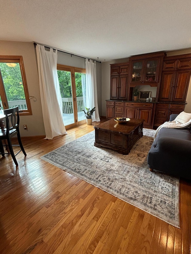 living room with a textured ceiling, a healthy amount of sunlight, and hardwood / wood-style flooring