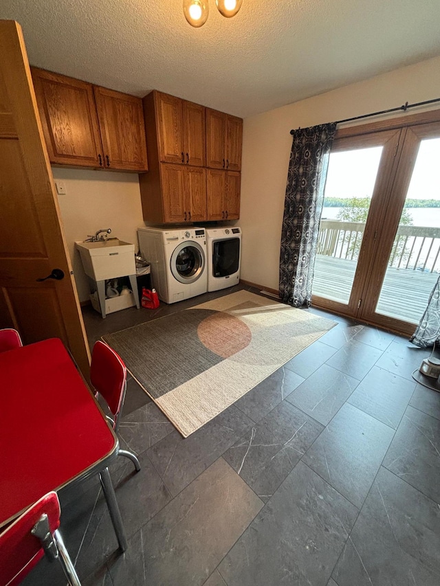 kitchen featuring a textured ceiling, washer and clothes dryer, and sink