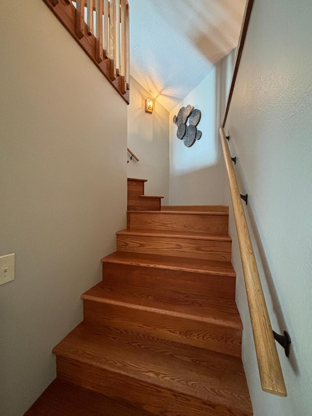staircase with a textured ceiling