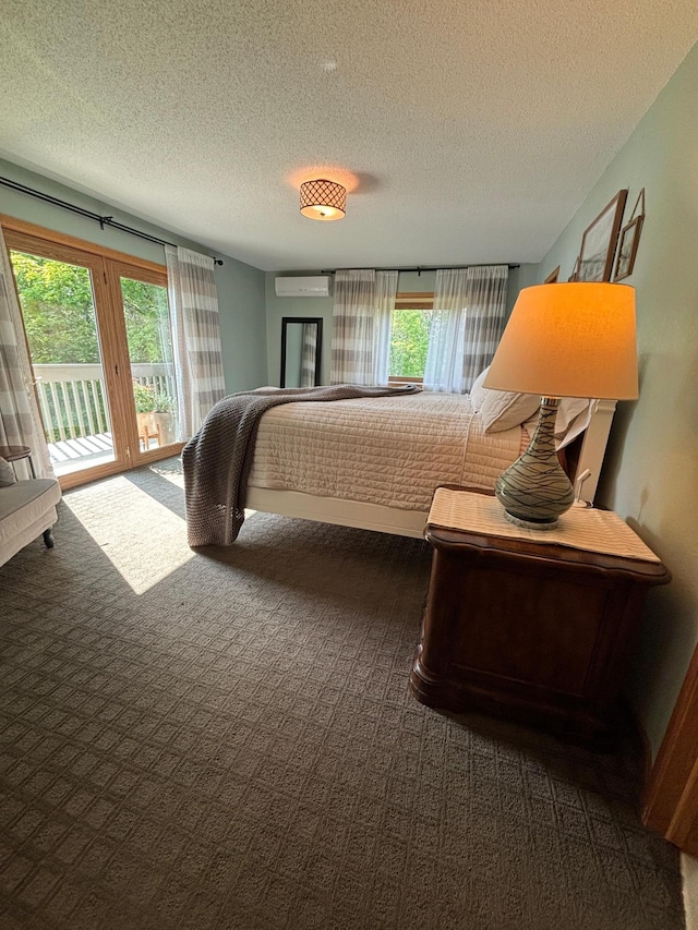 bedroom featuring multiple windows, a textured ceiling, and access to outside