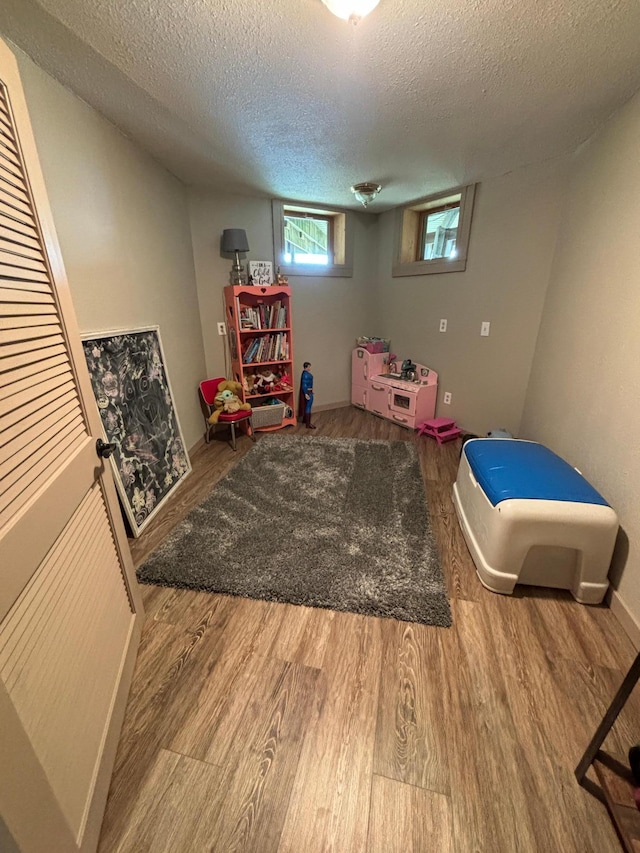 rec room featuring a textured ceiling and hardwood / wood-style floors