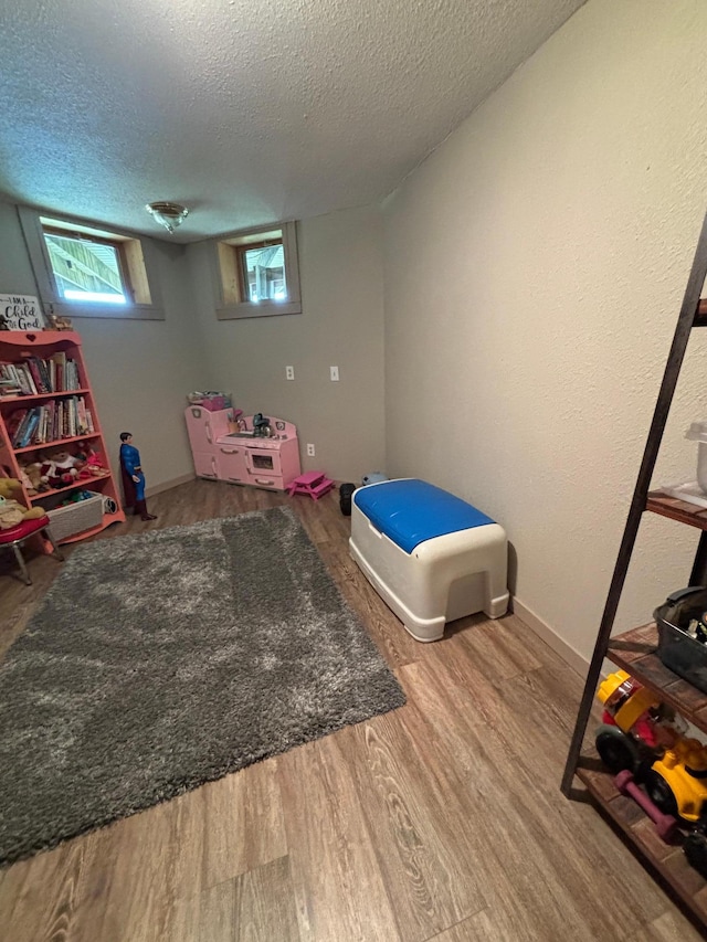 game room featuring hardwood / wood-style floors and a textured ceiling