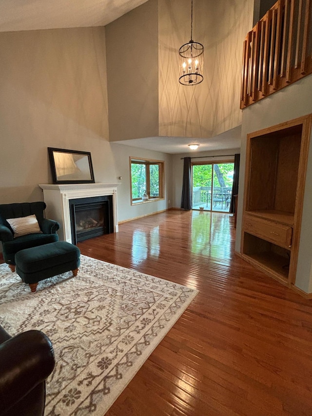 living room with high vaulted ceiling, hardwood / wood-style flooring, and a notable chandelier