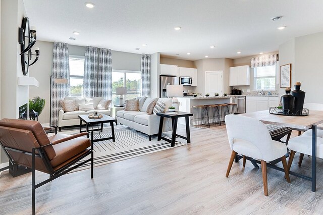 living room with sink and light hardwood / wood-style floors