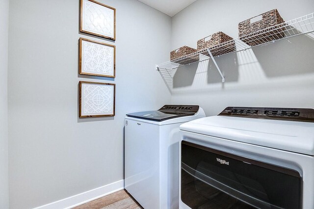 clothes washing area with light hardwood / wood-style floors and separate washer and dryer